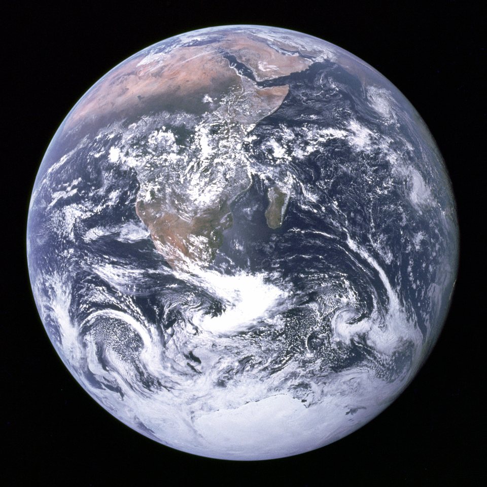 The Blue Marble: the whole, fully lit Earth against black space, with Africa, Arabia and the Antarctic ice cap under swirling white clouds